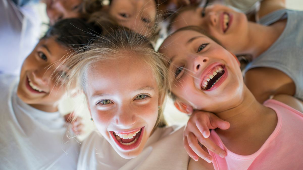 Niños sonriendo mientras aprenden inglés en un aula moderna